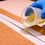 Epoxi-Reparatur eines Risses in einer massiven Eichenplatte mit Epoxidharz im Querformat