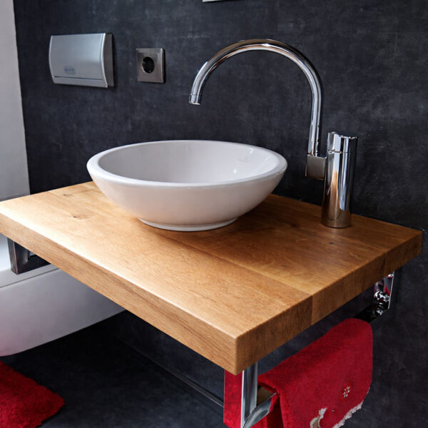 Waschtischplatte aus Holz mit gerader Kante und weißem Aufsatzwaschbecken im eleganten Badezimmer