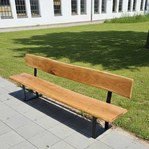 Hochwertige Gartenbank mit Rückenlehne aus massiver Eiche auf einer grauen Steinterrasse vor einem weißen Gebäude mit englischem Rasen.