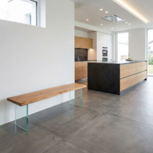 Eichenbank mit Glasuntergestell in moderner Küche auf großformatigen Fliesen