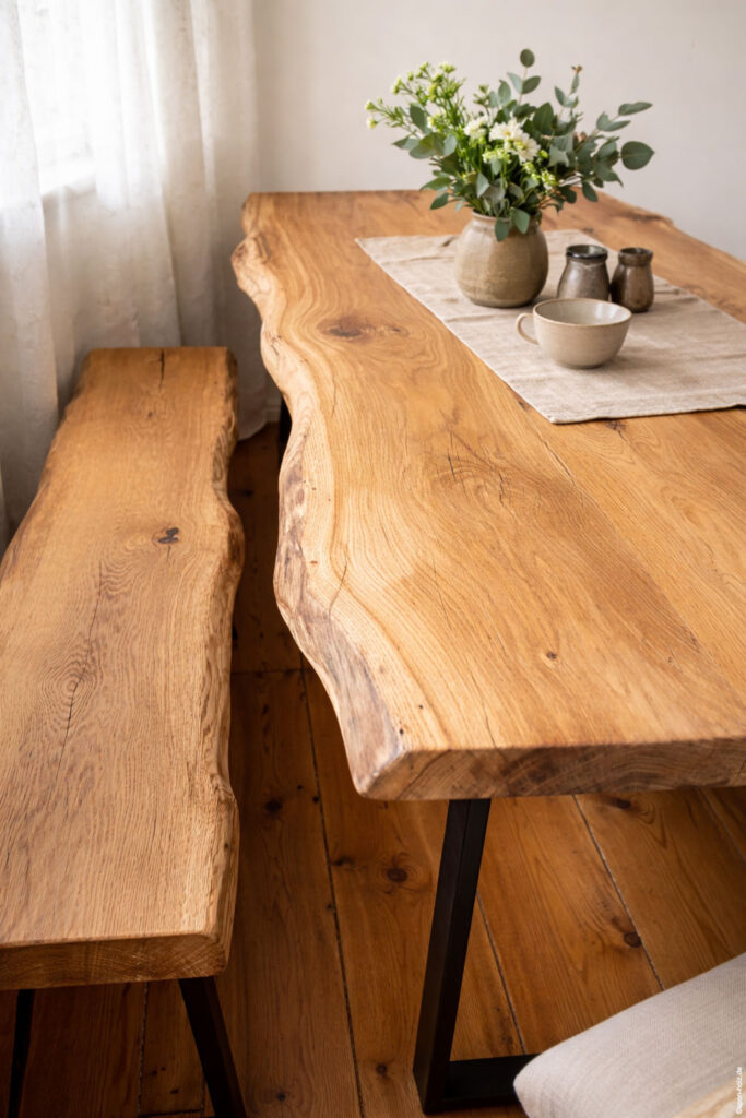 Massiver Eichen-Kufentisch mit rustikaler Naturkante und passender Kufenbank im Innenbereich