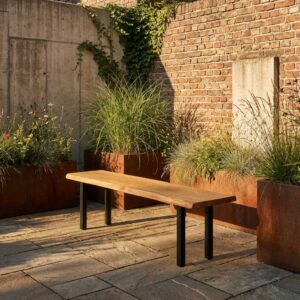 Gartenbank Holz aus massiver Eiche mit schwarzen Metallbeinen vor Backsteinwand